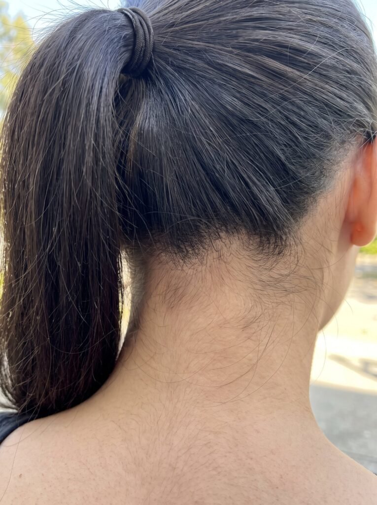 Fine dark hair on the nape of a woman’s neck